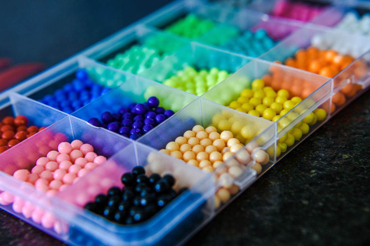Caja plástica con cuentas de colores organizadas