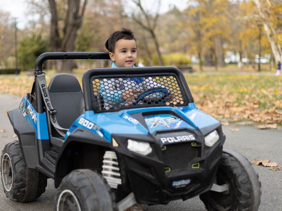 Niño con coche eléctrico infantil