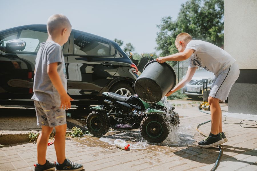 Niños lavando ATV de juguete